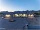 A modern home with desert landscaping and mountain views at dusk at 12560 E Cochise Dr, Scottsdale, AZ 85259