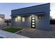 Modern home exterior featuring a covered entryway with rock landscaping and pathway to backyard at 12560 E Cochise Dr, Scottsdale, AZ 85259