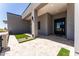 Modern home exterior featuring a covered entryway with travertine tile and minimal xeriscaping at 12560 E Cochise Dr, Scottsdale, AZ 85259