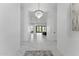 Bright hallway features marble floors and a modern crystal chandelier fixture at 12560 E Cochise Dr, Scottsdale, AZ 85259