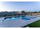 Backyard pool and spa with travertine tile and desert landscaping; illuminated at dusk at 12560 E Cochise Dr, Scottsdale, AZ 85259