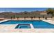 Stunning backyard pool and spa with travertine tile and desert landscaping against a mountain backdrop at 12560 E Cochise Dr, Scottsdale, AZ 85259