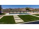 Inviting backyard pool and spa with travertine tile, green turf, desert landscaping, and mountain views at 12560 E Cochise Dr, Scottsdale, AZ 85259