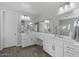 Bright bathroom featuring dual sinks with vanity, wood-look tile flooring, and large mirrors at 14369 W Wethersfield Rd, Surprise, AZ 85379