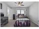 Cozy bedroom features a ceiling fan and a large window offering plenty of natural light at 14369 W Wethersfield Rd, Surprise, AZ 85379