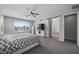 Bright bedroom featuring a barn door, ceiling fan, and ample natural light at 14369 W Wethersfield Rd, Surprise, AZ 85379