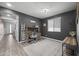 Modern home office features a ladder bookshelf, grey accent wall, a wooden desk, and neutral tones at 14369 W Wethersfield Rd, Surprise, AZ 85379