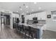 Modern kitchen features white cabinetry, stainless steel appliances, a large island, and pendant lighting at 14369 W Wethersfield Rd, Surprise, AZ 85379