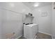 Bright laundry room featuring a white washer and dryer and a metal wire laundry basket at 14369 W Wethersfield Rd, Surprise, AZ 85379