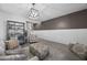 Cozy living room featuring stylish decor, modern lighting, and an open layout to the hallway at 14369 W Wethersfield Rd, Surprise, AZ 85379