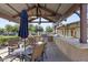 Covered outdoor kitchen featuring bar seating and built-in grills at 14369 W Wethersfield Rd, Surprise, AZ 85379