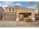 Home exterior featuring a two-car garage and covered entryway, set on a lot with desert landscaping at 15118 W Lincoln St St, Goodyear, AZ 85338