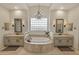 Elegant bathroom featuring dual vanities, a luxurious soaking tub, decorative lighting, and a walk-in shower at 1560 W Augusta Ave, Phoenix, AZ 85021