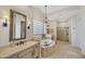 Elegant bathroom featuring dual vanities, a luxurious soaking tub, decorative lighting, and a walk-in shower at 1560 W Augusta Ave, Phoenix, AZ 85021