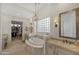 Elegant bathroom featuring dual vanities, a luxurious soaking tub, decorative lighting, and walk-in closet at 1560 W Augusta Ave, Phoenix, AZ 85021