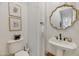 Traditional powder room with pedestal sink, decorative mirror, and elegant fixtures at 1560 W Augusta Ave, Phoenix, AZ 85021