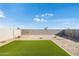 Landscaped backyard with artificial turf and block wall at 17747 W Mission Ln, Waddell, AZ 85355