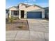 New single-story home with light-colored exterior and blue garage door at 17747 W Mission Ln, Waddell, AZ 85355