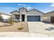 Single-story home with gray garage door and landscaping at 17747 W Mission Ln, Waddell, AZ 85355