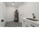 Bright laundry room with white cabinets, patterned floor, and modern sink at 17831 N 130Th Ave, Sun City West, AZ 85375