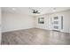 Spacious living room featuring light gray wood-look floors and a modern ceiling fan at 17831 N 130Th Ave, Sun City West, AZ 85375