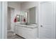 Bathroom with granite vanity, white cabinets, and large mirror at 18242 W Colter St, Litchfield Park, AZ 85340