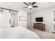 Main bedroom with wooden bed frame, TV, and access to bathroom at 19042 W Clinton St, Surprise, AZ 85388