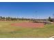 Well-maintained baseball field with green grass, dirt infield, and tall lights for evening games at 20620 W Walton Dr, Buckeye, AZ 85396