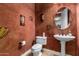 Cozy bathroom with a pedestal sink and unique wall decor and earth tone colors at 20620 W Walton Dr, Buckeye, AZ 85396