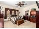 Well-lit bedroom features a ceiling fan and dark wood furniture at 20620 W Walton Dr, Buckeye, AZ 85396