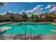 Blue community pool surrounded by lounge seating and wrought iron fence separating neighborhood at 20620 W Walton Dr, Buckeye, AZ 85396