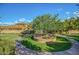 Tranquil community space with mature tree, circular walking path and lush grass at 20620 W Walton Dr, Buckeye, AZ 85396