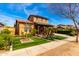 Charming home with a covered front porch, lush green lawn, and desert-friendly landscaping at 20620 W Walton Dr, Buckeye, AZ 85396