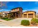 Beautiful two-story home with stone accents, covered front porch, and a well-manicured lawn at 20620 W Walton Dr, Buckeye, AZ 85396