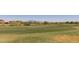 Expansive view of a green golf course with mountains in the distance under a clear sky at 20620 W Walton Dr, Buckeye, AZ 85396