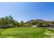 Picturesque golf course with a bridge, pond, and mountain views on a clear, sunny day at 20620 W Walton Dr, Buckeye, AZ 85396