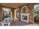 Outdoor fireplace under covered patio featuring a stone surround and concrete table with benches at 20620 W Walton Dr, Buckeye, AZ 85396