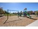 Community playground with swings, slides, climbing structures and shaded areas on wood chips at 20620 W Walton Dr, Buckeye, AZ 85396