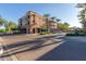 View of a commercial street with a brick-paved road, palm trees, shops, and available street parking at 20620 W Walton Dr, Buckeye, AZ 85396