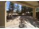 Inviting covered back patio with stone flooring, built-in planters, and views of the lush, mature landscaping at 2113 E Sunland Ave, Phoenix, AZ 85040