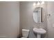 Small powder room with pedestal sink and oval mirror at 2477 W Market Pl # 55, Chandler, AZ 85248