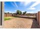 Expansive backyard featuring a dirt landscape, block fencing, and views of neighboring houses at 3129 W Fremont Rd, Phoenix, AZ 85041