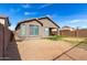 View of the backyard with a dirt landscape, block fencing, and a covered patio area at 3129 W Fremont Rd, Phoenix, AZ 85041