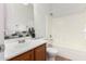 Bright bathroom with a wood vanity, single sink, and a shower-tub combination with modern fixtures at 3129 W Fremont Rd, Phoenix, AZ 85041