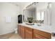 Well-lit bathroom featuring a double sink vanity, decorative mirror, and a combination shower and bathtub at 3129 W Fremont Rd, Phoenix, AZ 85041