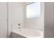 Clean white bathtub with tile surround and modern fixtures in a bright, neutral bathroom at 3129 W Fremont Rd, Phoenix, AZ 85041