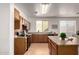 Efficient kitchen layout with wood cabinets, black appliances, and a view to the dining area at 3129 W Fremont Rd, Phoenix, AZ 85041