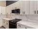 Kitchen features white cabinets, quartz counters and black appliances at 4213 E Stanford Ave, Gilbert, AZ 85234