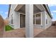 Home back porch featuring brick floor, pillars, and a sliding glass door and windows at 4412 N 203Rd Dr, Buckeye, AZ 85396