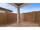 Backyard patio with brick floor, landscaping and a tall backyard fence at 4412 N 203Rd Dr, Buckeye, AZ 85396